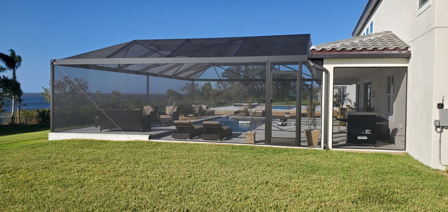 A large open air patio with a pool and a grassy area.